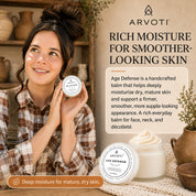 A jar of Arvoti Age Defense Balm with a rustic indoor setting. The image includes product packaging, descriptive text, and decorative elements like ceramic pots and a lace cloth. Highlighting deep moisture for mature, dry skin.